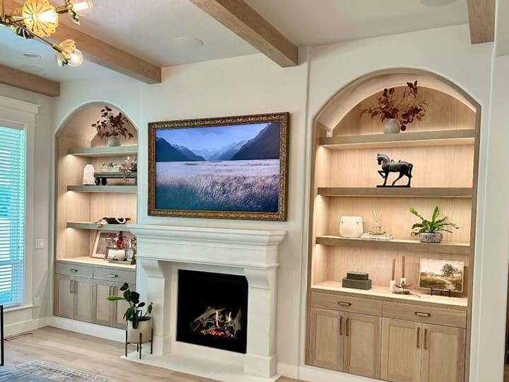 Arched white oak built-ins beside a fireplace